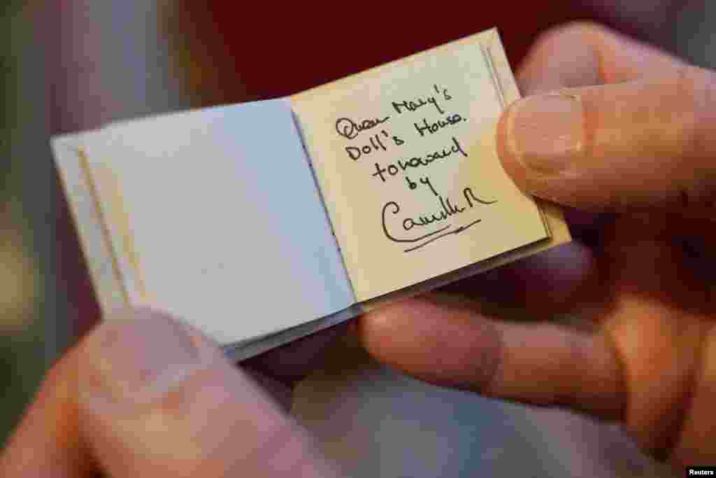 Glenn Bartley, head of the Royal Bindery, shows a miniature book, written by Britain&#39;s Queen Camilla, during a reception at Windsor Castle for authors, illustrators and binders who have been involved in the new Miniature Library collection displayed alongside Queen Mary&#39;s Dolls&#39; House for visitors to enjoy throughout 2024 in celebration of its centenary year in Windsor.&nbsp;