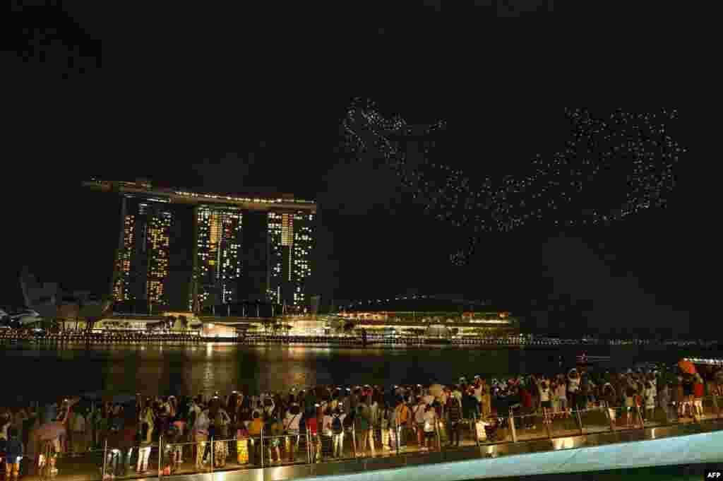 People gather to watch drones forming a dragon during a performance titled&nbsp;&#39;The Legend Of The Dragon Gate&#39; above the Marina Bay waterfront on the first day of the Lunar New Year in Singapore, Feb. 10, 2024.