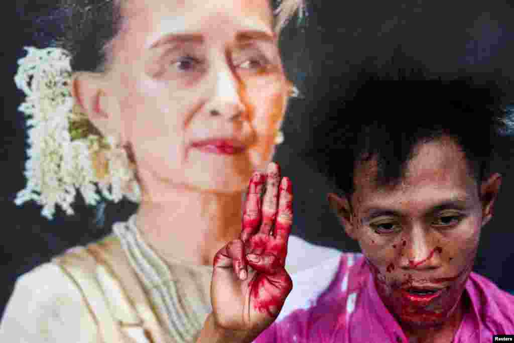 A protester with fake blood on his body raises a three-finger salute in a demonstration to mark the third anniversary of Myanmar&rsquo;s 2021 military coup, outside of the United Nations office in Bangkok, Thailand.