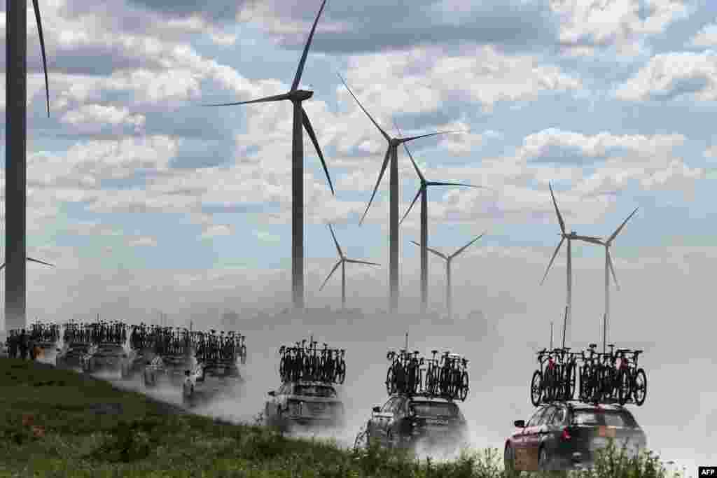 Team direction vehicles with bicycles on their roofs drive through dust over the Plateau de la Cote des Bar &quot;Chemin Blanc&quot; (white road) gravel sector during the 9th stage of the 111th edition of the Tour de France cycling race, 199km stage departing and finishing in Troyes, France.