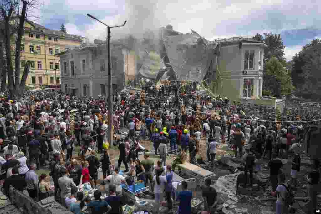 Rescuers and volunteers clean up the rubble and search victims after Russian missile hit the country&#39;s main children hospital Okhmadit in Kyivd during massive missile attack on many Ukrainian cities,