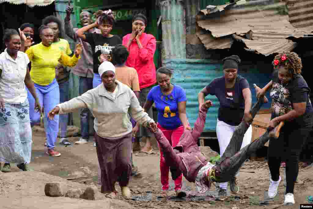 Women carry a supporter of Kenya&#39;s opposition leader Raila Odinga, who was shot during an anti-government protest against the imposition of tax hikes by the government, in Mathare settlement in Nairobi.