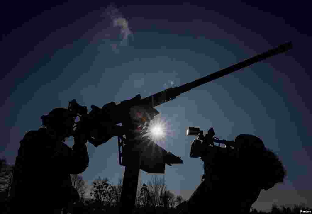 A cameraman films a Ukrainian serviceman from an air defence unit, amid Russia's attack on Ukraine, near Kyiv, Jan. 29, 2024. 