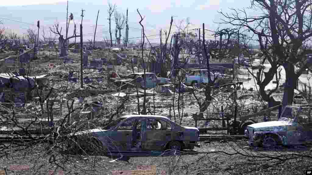 Destroyed homes and cars are seen, Aug. 13, 2023, in Lahaina, Hawaii. Hawaii officials urge tourists to avoid traveling to Maui as many hotels prepare to house evacuees and first responders on the island where a wildfire demolished a historic town and killed dozens.&nbsp;
