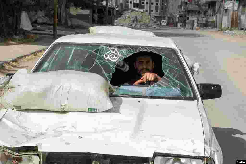 A displaced Palestinian man drives a car damaged during Israel&#39;s military offensive as he flees Rafah, after Israeli forces launched a ground and air operation in the eastern part of southern Gaza city.