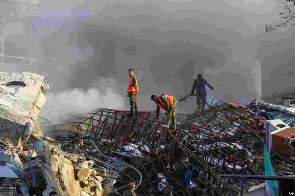 Emergency personnel extinguish a fire at the site of strikes which hit a building in Syria&#39;s capital Damascus.&nbsp;Syrian state media said Israeli strikes destroyed the Iranian consular section.