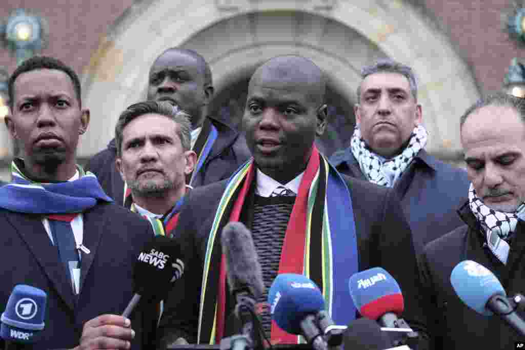 South Africa&#39;s Minister of Justice and Correctional Services Ronald Lamola, center, and Palestinian assistant Minister of Multilateral Affairs Ammar Hijazi, right, address the media outside the International Court of Justice in The Hague, Netherlands.&nbsp;The United Nations&#39; top court opens hearings into South Africa&#39;s allegation that Israel&#39;s war with Hamas amounts to genocide against Palestinians, a claim that Israel strongly denies.