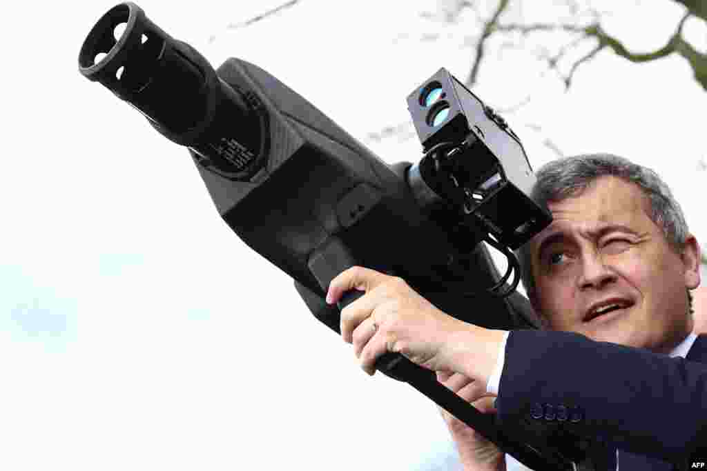 France&#39;s Minister for Interior and Overseas Gerald Darmanin holds an anti-drone weapon during the Olympic flame&#39;s journey, in Beynes, west of Paris.