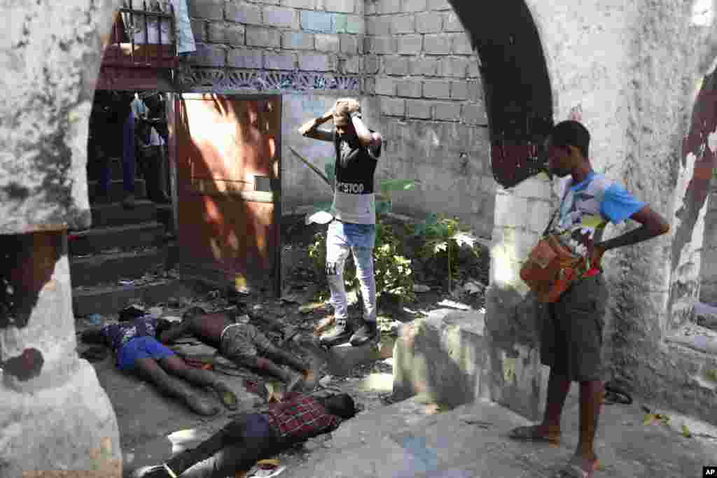 People look at the the bodies of three persons shot dead after an overnight shooting in the Pétion Ville neighborhood of Port-au-Prince, Haiti, April 1, 2024.