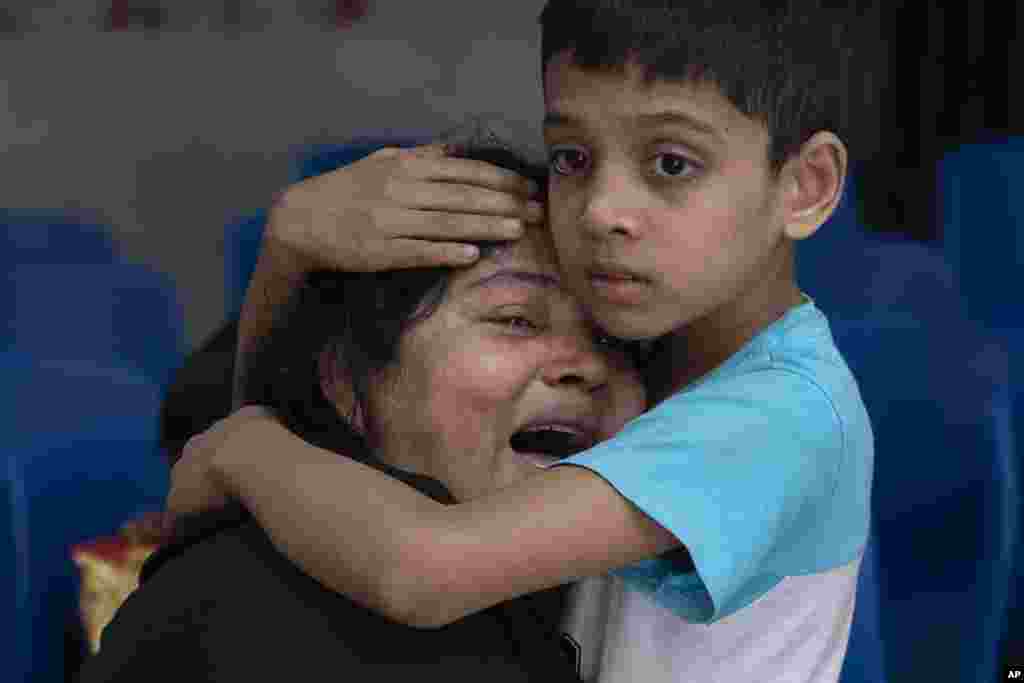 Rakibul, 6, comforts his mother Rehana mourning the death of her husband, Mohammad Zillur, at a hospital in Munshiganj, outside Dhaka.&nbsp;Zillur, a supporter of a candidate from the ruling Awami League, was stabbed to death as Bangladesh voted in a parliamentary election boycotted by the main opposition party.