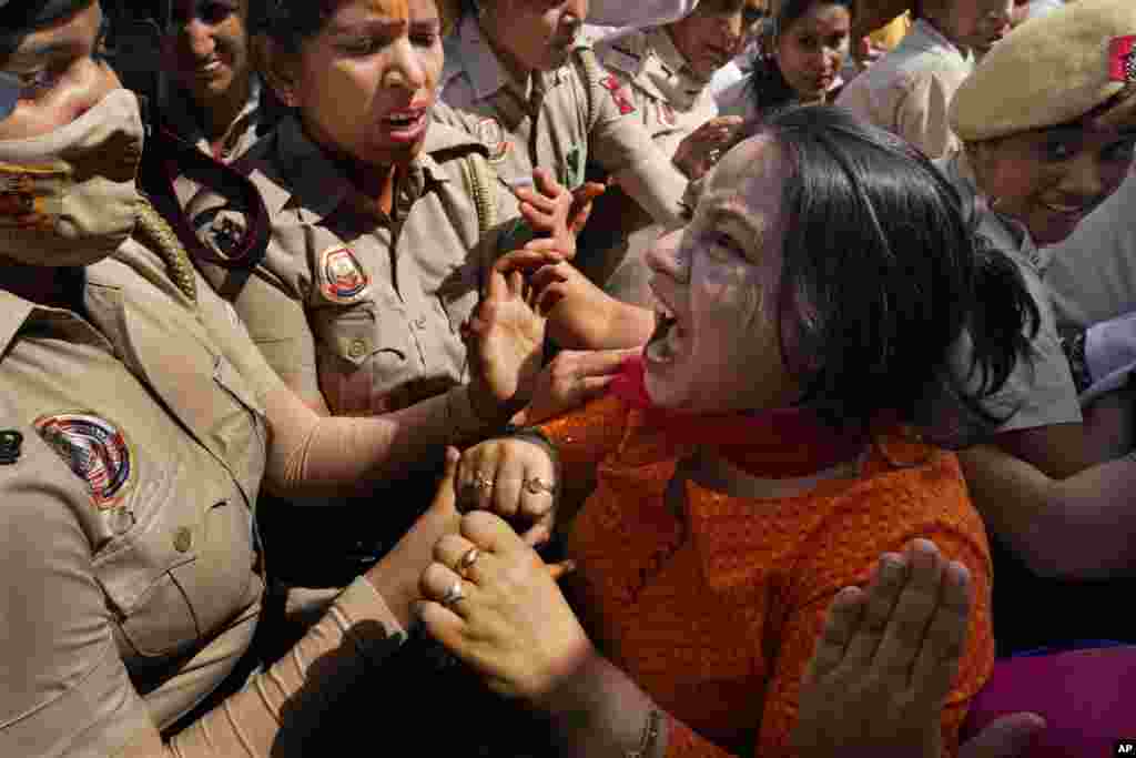 A member of Aam Admi Party, or Common Man&#39;s Party, screams as she is detained by the police during a protest against the arrest of their party leader Arvind Kejriwal in New Delhi, India.