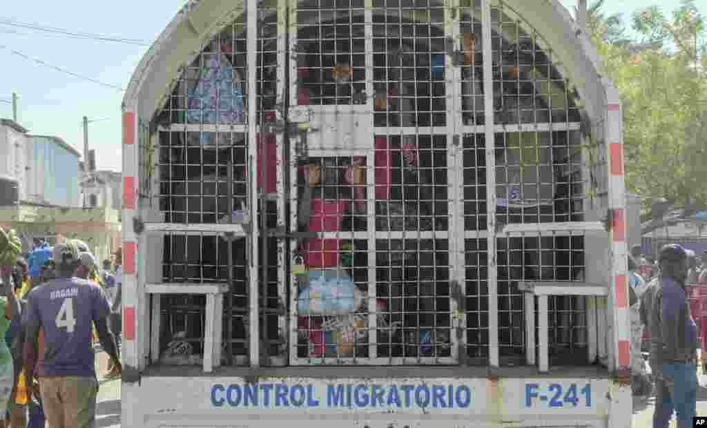 People who were detained for deportation to Haiti, stand inside a police truck on the border bridge that connects Dajabon, Dominican Republic with Haiti.