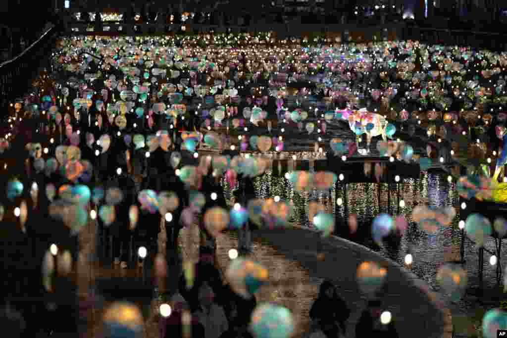 People walk along Cheonggye stream under the lanterns which is displayed for the Seoul Lantern Festival, on the New Year's eve at downtown Seoul, South Korea, Dec. 31, 2023. 