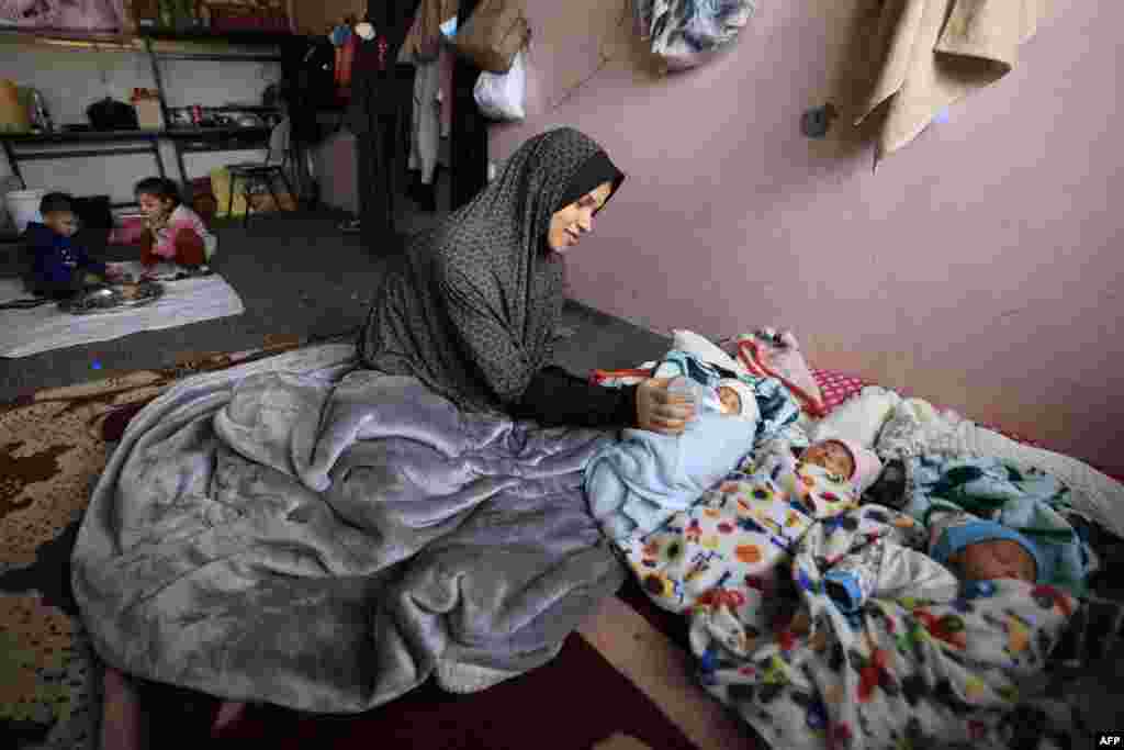 Iman al-Masri, a displaced Palestinian who fled from her home in Beit Hanoun with her family to escape Israeli bombardment, feeds one of her quadruplets &mdash; with the fourth still being treated in hospital &mdash; as they take shelter at a school in Deir al-Balah in the central Gaza Strip.