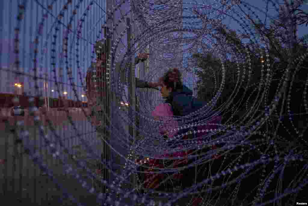 Eliana, 22, a migrant from Venezuela, holds her three-year-old daughter Chrismarlees as she shouts towards an Army National Guard soldier&nbsp;after he halted her from breaching a razor wire-laden fence along the bank of the Rio Grande river in El Paso, Texas, March 26, 2024.
