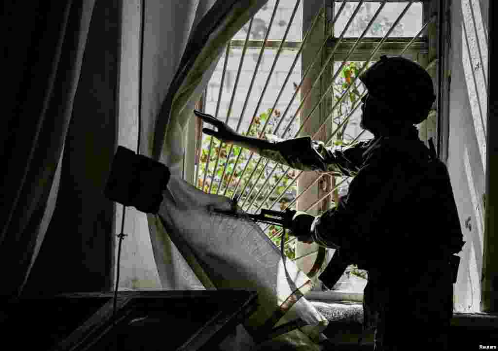 A Ukrainian serviceman patrols an area heavily damaged by Russian military strikes, amid Russia's attack on Ukraine, in the town of Orikhiv in Zaporizhzhia region, May 20, 2024. 
