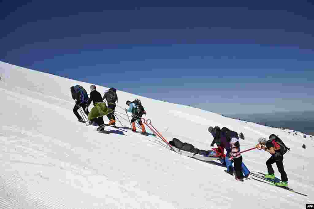 Volunteers pull a person with disabilities on a snow stretcher at 2507 meter high as they climb the Rila Mountain, southwestern Bulgaria, March 23, 2024.&nbsp;More than 50 volunteers came together to help five people with various disabilities to reach the snow-covered peaks of the Rila Mountain.
