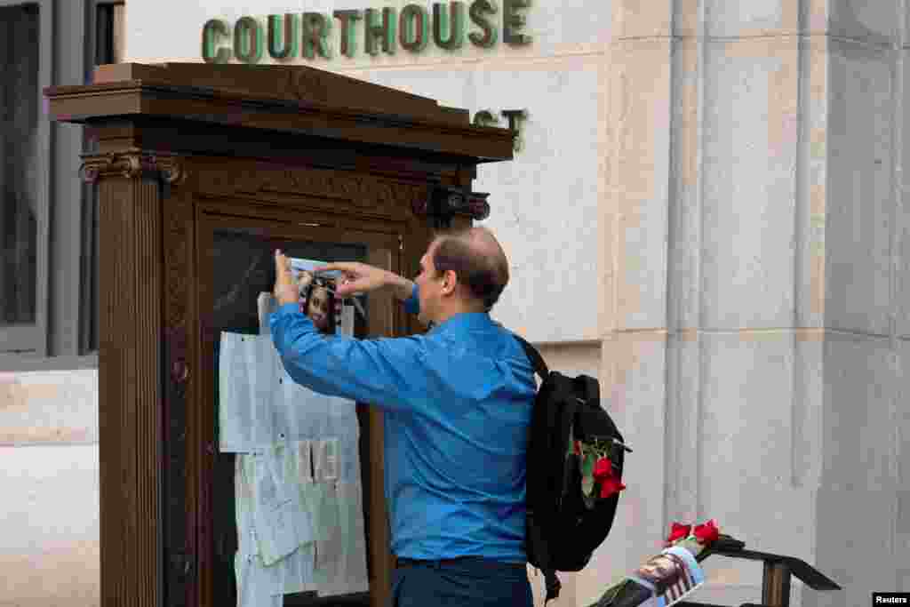 A supporter places roses and a photo of Fulton County District Attorney Fani Willis near the entrance of the Lewis R. Slaton Courthouse in Atlanta, Georgia, after a Grand Jury brought back indictments against former president Donald Trump and 18 of his allies in their attempt to overturn the state&#39;s 2020 election results.