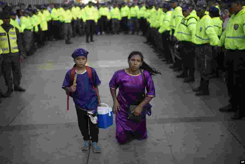 A penitent walks on her knees in the Nazarene of Saint Paul Holy Week procession, outside the Basilica of St. Teresa, in Caracas, Venezuela, March 27, 2024. 