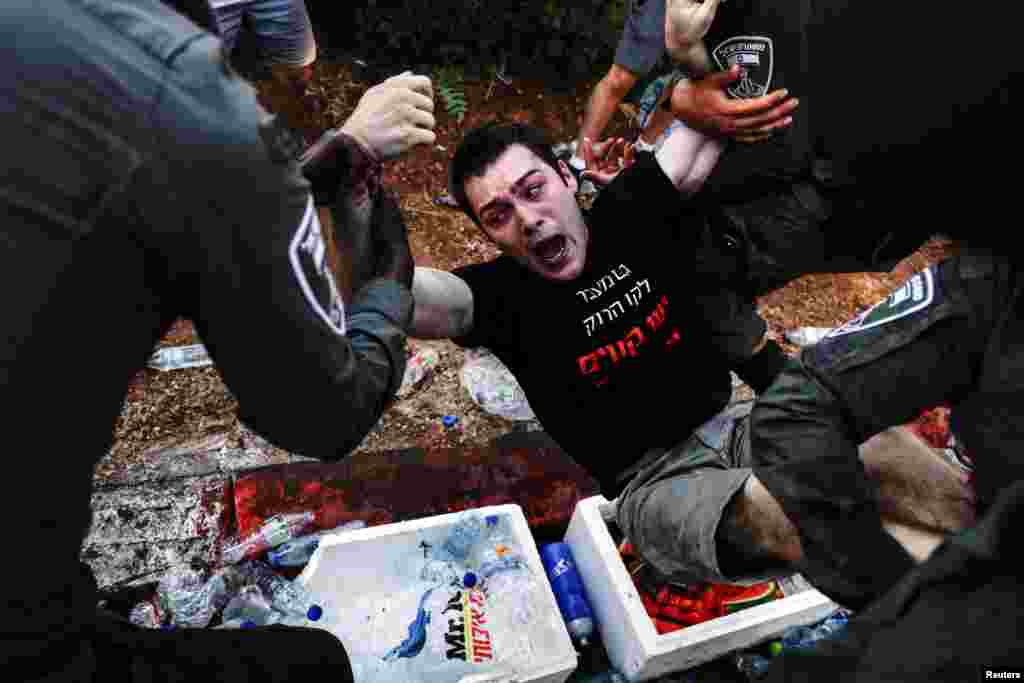 Israeli security forces clash with a protester during a demonstration against Israeli Prime Minister Benjamin Netanyahu and his nationalist coalition government&#39;s judicial overhaul, in Jerusalem.