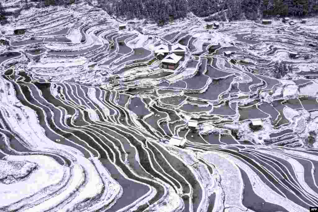 The aerial view shows snow-covered terraced fields and houses in Congjiang county, in China&#39;s southwestern Guizhou province.