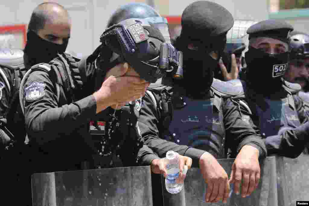 A police officer washes his face as protesters gather near the Turkish Embassy during a demonstration against cutting Iraq&#39;s water supply, in Baghdad.