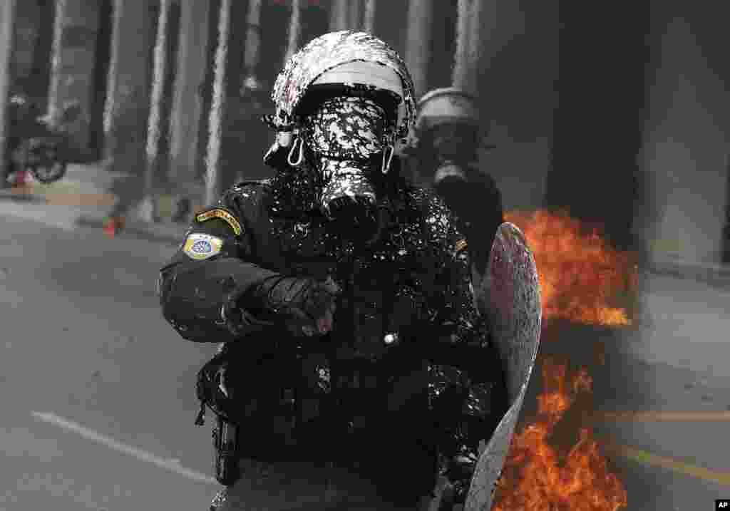 A riot policeman is covered with white paint thrown by protesters during clashes in the northern port city of Thessaloniki, Greece.&nbsp;Widespread strikes in Greece disrupted transport services, halting ferries and trains, in protests timed to coincide with the anniversary of a deadly rail crash a year ago.&nbsp;