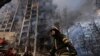 2022年3月15日乌克兰首都基辅一名消防人员在遭到炮火摧毁的一栋公寓楼前