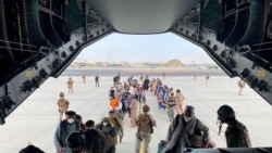Afganët duke hyrë në avionin transportues