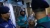 ঢাকায় ট্রেন অগ্নিসংযোগে নিহত মানুষের কাপড়ে ঢাকা লাশের পাশে পুলিশ কর্মকর্তা। 