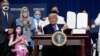President Donald Trump displays an executive order he signed at a campaign event on health care at Charlotte Douglas International Airport in Charlotte, N.C., Sept. 24, 2020.