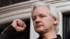 El fundador de Wikileaks Julian Assange levanta su puño antes de dirigirse a los medios en el balcón de la Embajada de Ecuador en Londres, el 19 de mayo de 2017.