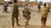 Des soldats de l'armée malienne patrouillent avec des soldats de la force française Barkhane dans une rue de Menaka dans la région de Liptako au Mali le 21 mars 2019.