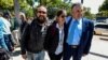 El fotógrafo colombiano Leonardo Muñoz (I) y la periodista colombiana Mauren Barriga Vargas (C) aparecen en la foto junto al encargado de negocios de Colombia en Venezuela, Germán Castaneda, luego de ser liberado de la detención por las autoridades venezolanas, en Caracas.