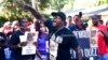 In this May 5, 2020, photo, Keith Smith speaks to a crowd as they march through a neighborhood in Brunswick, Ga. 