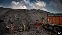 Indian laborers load coal into a truck in Dhanbad, an eastern Indian city in Jharkhand state, Friday, Sept. 24, 2021. (AP Photo/Altaf Qadri)