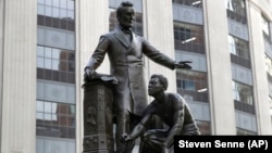 Patung yang menggambarkan budak yang dibebaskan berlutut di hadapan Presiden Abraham Lincoln, di Boston, 25 Juni 2020. (Foto: AP)