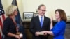 New York Chief Judge Janet DiFiore, left, swears in Kathy Hochul, right, as the first woman to be New York's governor while her husband Bill Hochul holds a bible during a swearing-in ceremony in the Red Room at the state Capitol, early Tuesday, Aug…