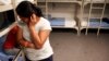 Una mujer y un niño guatemaltecos no identificados son vistos dentro de un dormitorio en el Centro Residencial Familiar de Artesia, un centro de detención federal para madres e hijos de inmigrantes indocumentados en Artesia, Nuevo México, 10 de septiembre de 2014.