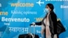 Një udhëtare me maskë mbërrin në aeroportin e Nju Jorkut