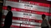 香港金融中心人行道旁的数字屏显示下跌股票指数（2015年8月25日）。