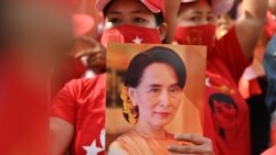 A Myanmar migrant holds up an image of Aung San Suu Kyi