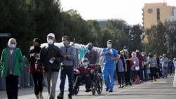 Njerëzit presin në radhë për t'u vaksinuar në Disneyland