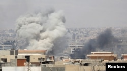 De la fumée est visible après un assaut de l'armée irakienne à Mossoul, Irak, le 25 juin 2017.