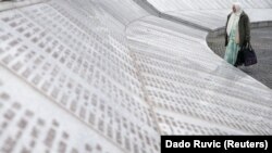 Një grua pranë varreve të anëtarëve të saj të familjes në Potocari, pranë Srebrenicës