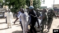 Photo d’archives : Les forces de sécurité aidant à transporter certaines des 11 victimes d'une double explosion à Maroua, ville du nord du Cameroun, le 22 juillet 2015.