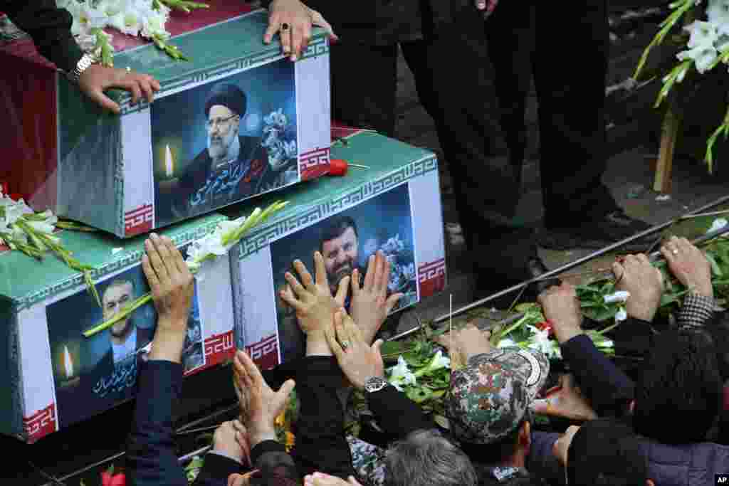 In this photo provided by Fars News Agency, mourners try to touch the coffins of Iranian President Ebrahim Raisi, top, Foreign Minister Hossein Amirabdollahian, left, and Raisi&#39;s chief bodyguard Gen. Mehdi Mousavi, who were killed in a helicopter crash on Sunday in a mountainous region of the country&#39;s northwest, during a funeral ceremony at the city of Tabriz.&nbsp;