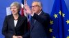 El presidente de la Comisión Europea, Jean-Claude Juncker (D), saluda a la primera ministra británica Theresa May en la sede de la UE en Bruselas, el miércoles 21 de noviembre de 2018.