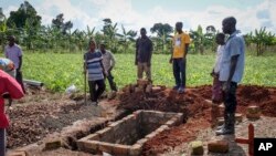Watu wakitengeneza kaburi, kumzika mwanamke aliyefariki kutokana na Ebola, katika kijiji cha Kijavuzo, wilayani Mubende. Sept 29, 2022
