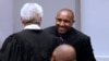 L'ancien chef de guerre congolais Bosco Ntaganda salue son avocat Stéphane Bourgon, dans la salle d'audience de la Cour pénale internationale lors des déclarations finales de son procès à La Haye, le 28 août 2018.